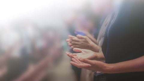Hands of church goers lifted in prayer