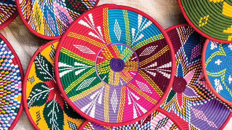 Multi-colored woven baskets with white hand-painted design